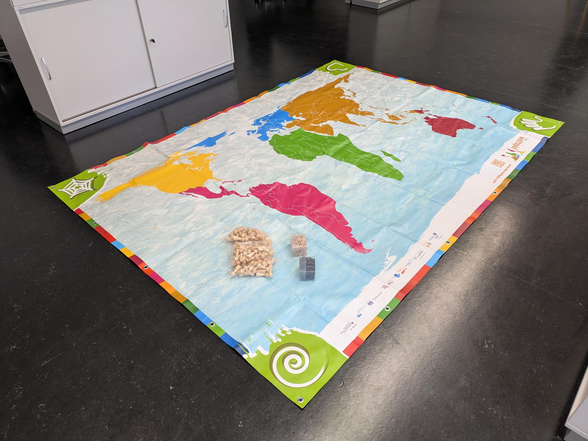 Weltspielkarte mit Spielfiguren und -steinen.